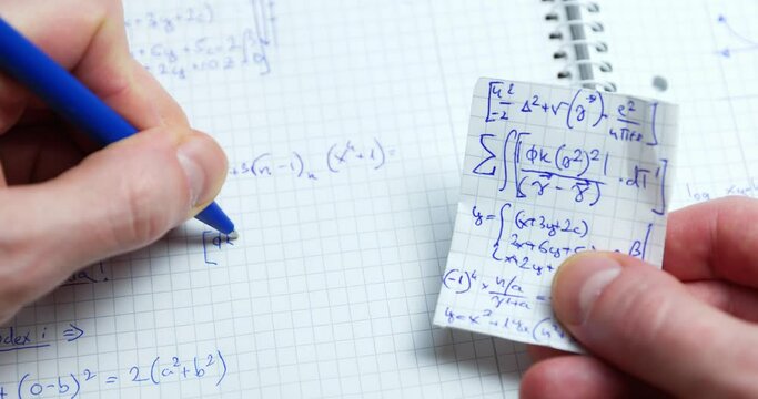 Man writing math exercise in notebook closeup