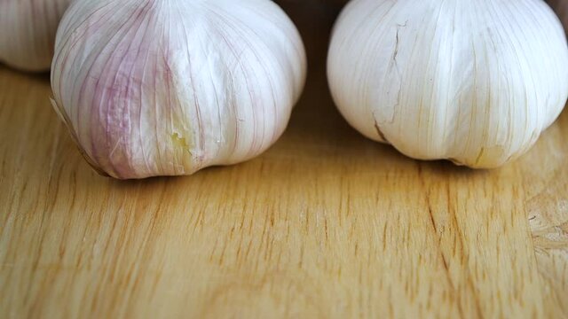 Top view slow motion of pouring garlic on wooden table