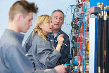 teacher observing students working on electrical circuits