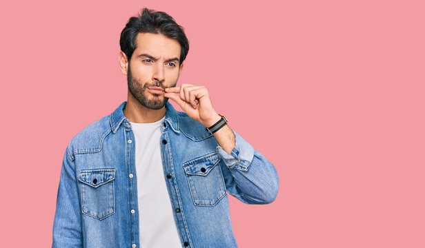 Young hispanic man wearing casual clothes mouth and lips shut as zip with fingers. secret and silent, taboo talking