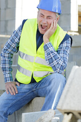 builder man touching face with hurting expression toothache