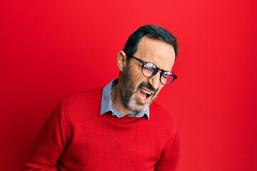 Fototapeta premium Middle age hispanic man wearing casual clothes and glasses with hand on stomach because nausea, painful disease feeling unwell. ache concept.