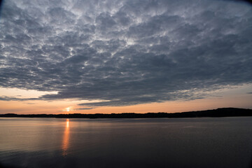 Fototapeta na wymiar Clearing Clouds at Sunrise Dawn on Tranquil Lake