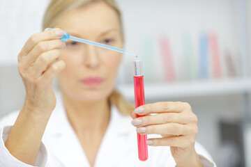 mature woman looks at pipette results