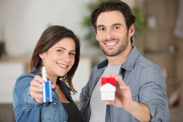 smiling couple holding cigarette packet and e-cigarette