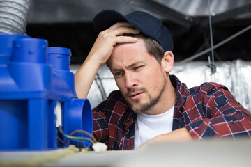 confused tradesman trying to fit an air conditioning unit