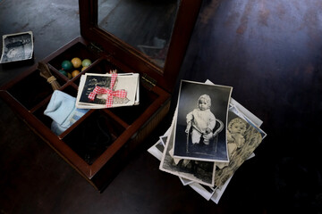 female hands are sorting dear to heart memorabilia in an old wooden box, stack of photos, vintage photographs of 1960, concept of family tree, genealogy, childhood memories, connection with ancestors