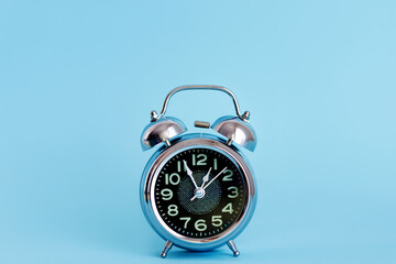 Black Vintage Alarm Clock on Blue Background