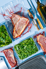 vacuum packed raw beef steaks ready to fry. t-bone steak from marbled beef. meat and vegetables