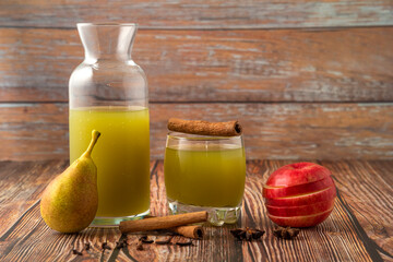 Green pear and red apple with a glass of juice