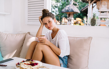 Pensive woman enjoying drinking hot coffee