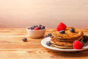 Pancakes And Berries On Wooden Background