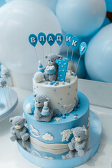 Candy bar. Baby birthday theme with teddy bear. Festive background decoration with cake, letters saying one and white blue balloons in studio.