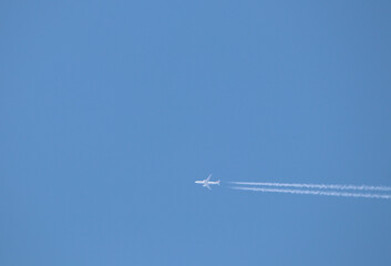 The air plane fast movement with condensation lines on the blue sky