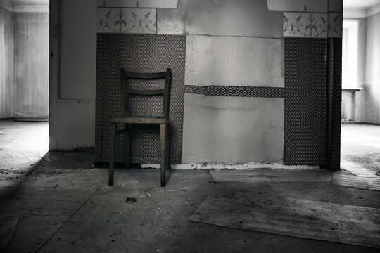 An antique chair in an old abandoned house. Shabby walls. Wooden chair. Empty room.