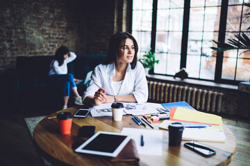 Positive woman sitting at table in coworking space