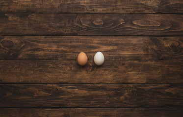 two different colored chicken eggs on wooden background