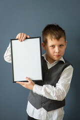 boy 8-10 years old in a white shirt on a dark background with a frame, space for text, selective...