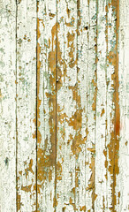 Cracking and peeling white paint on a wall. Vintage wood background with peeling paint. Old board with Irradiated paint. White wooden texture, wood background with old paint peels. Paint desk texture.