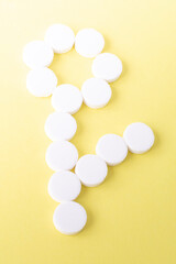 a flower of round white pills on a yellow background. The concept of medicine and medical care