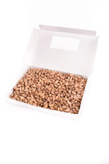 Roasted salted pistachios in white box on white background