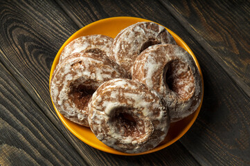 Homemade round gingerbread cookies with icing in yellow plate. Idea for a delicious breakfast or dinner. Top view