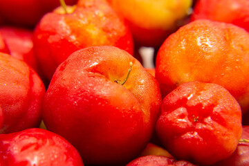 Close em monte de acerolas maduras, empilhadas.