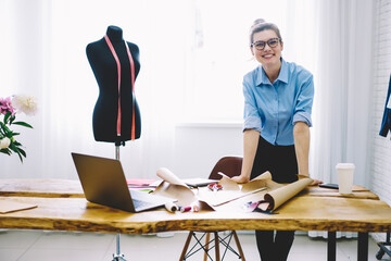 Cheerful woman working in modern atelier