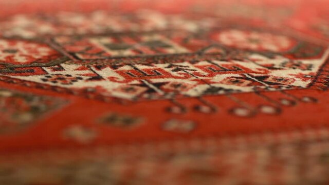 persian carpet beautiful ornament soft woolen texture close-up, shallow depth of field, motion, abstract background