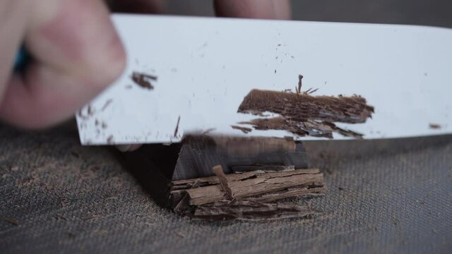 Caucasian hands cuts chocolate for a cake. Closeup view, dessert concept