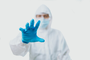 People wearing medical gloves and personal protective equipment, mask, goggle and suit to protect...
