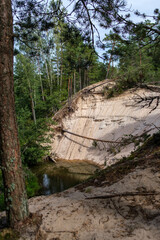 sandstone cliffs on the shore of forest river in Latvia