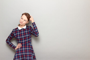 Portrait of thoughtful puzzled girl scratching her head with finger