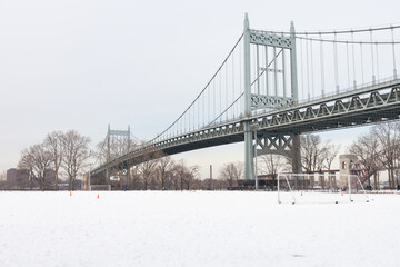 Empty Field Covered with Snow at Astoria Park with the Triborough Bridge in Astoria Queens New York during Winter