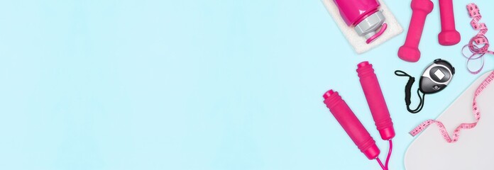 Weight loss cardio workout concept. Jump rope, dumbbells, stopwatch, body weight scale, water bottle, measure tape on blue background. Copy space. Sports and fitness banner