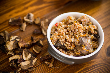 boiled buckwheat with organic forest dried mushrooms in a ceramic bowl