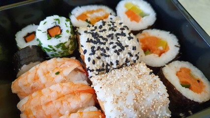 Different types of sushi on a black tray