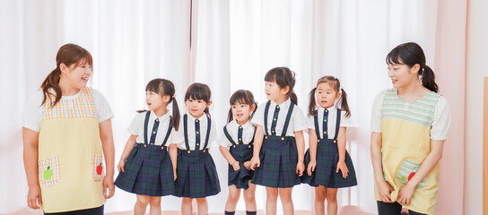 Obraz premium 発表会の練習をする子どもたちと保育士