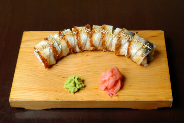 rolls smoked eel soft cheese ginger wasabi served on a wooden stand on a dark background healthy food
