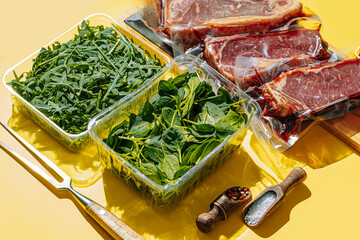 vacuum packed raw beef steaks ready to fry. t-bone steak from marbled beef. meat and vegetables