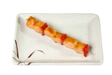 shish kebab from a salmon in sweet-sour sauce on a plate it is isolated on a white background