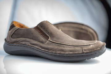 Men's leather loafers of brown color close-up on a light background.