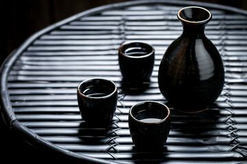 Sake in black ceramics on black table. Japanese cuisine.