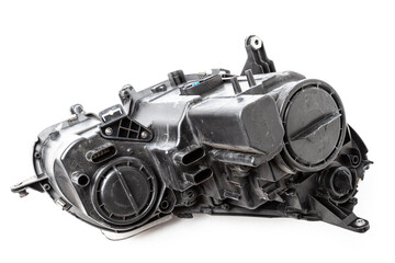 Spare part made of black plastic, rear view on white background in a photo studio for a catalog - a xenon headlight inside electrical systems and optical equipment assemblies of a lamp and reflectors