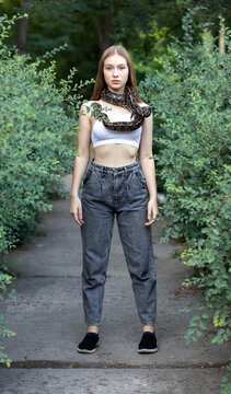 Young model standing with a snake around her neck
