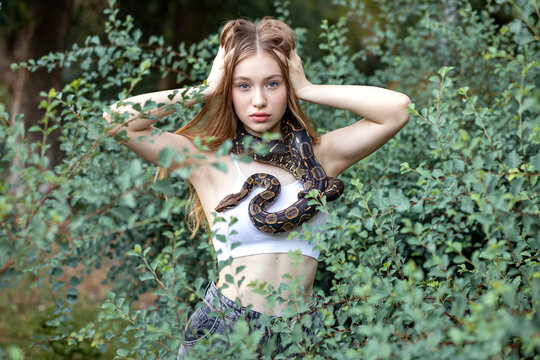 Model looking at camera, tossing her hair and having a snake around her neck