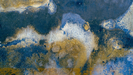 An old textured wall with different shades of blue and yellow.