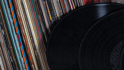 two vinyl records lean against a pile of vinyl records