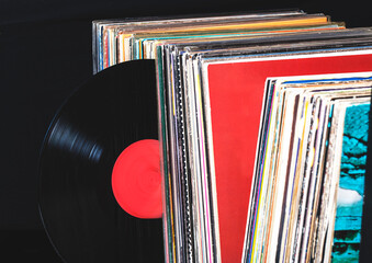 a record hangs out of a pile of records