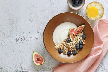 Muesli cereal mix with yogurt, fig and blueberries. Top view, copy space